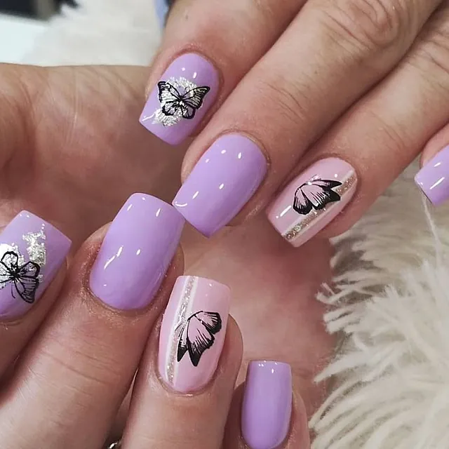 Mariposas en uñas pintadas de lila y rosa palo